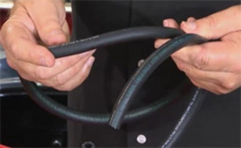 Man holding 2 types of rubber fuel line