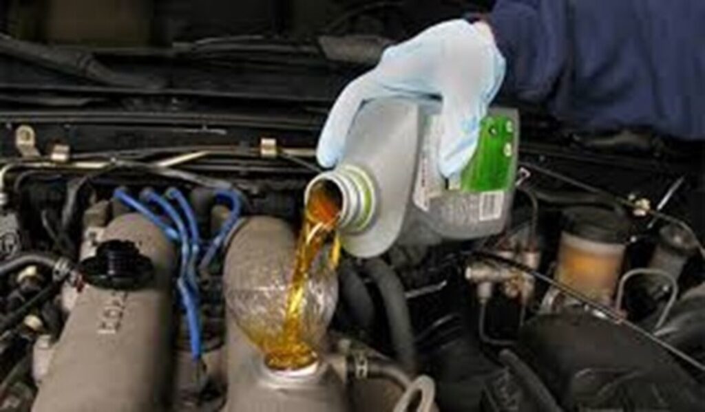 Pouring oil into classic car engine