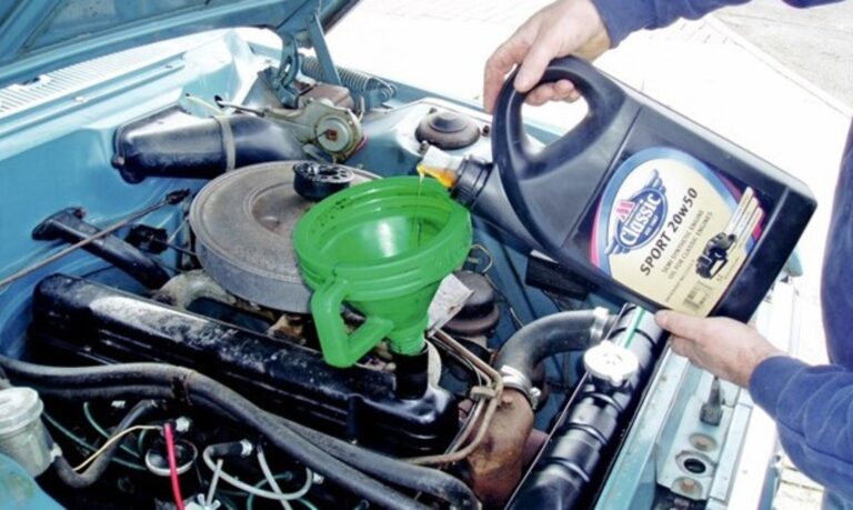 Pouring oil into classic car engine