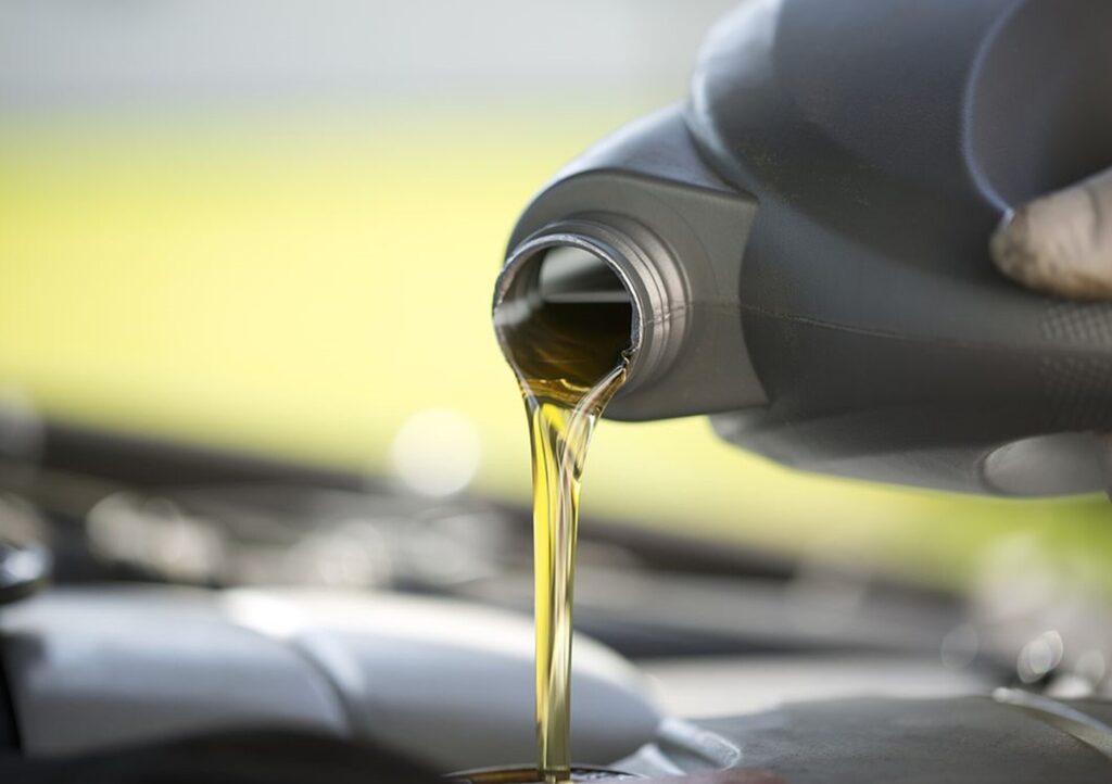 Pouring oil into classic car engine