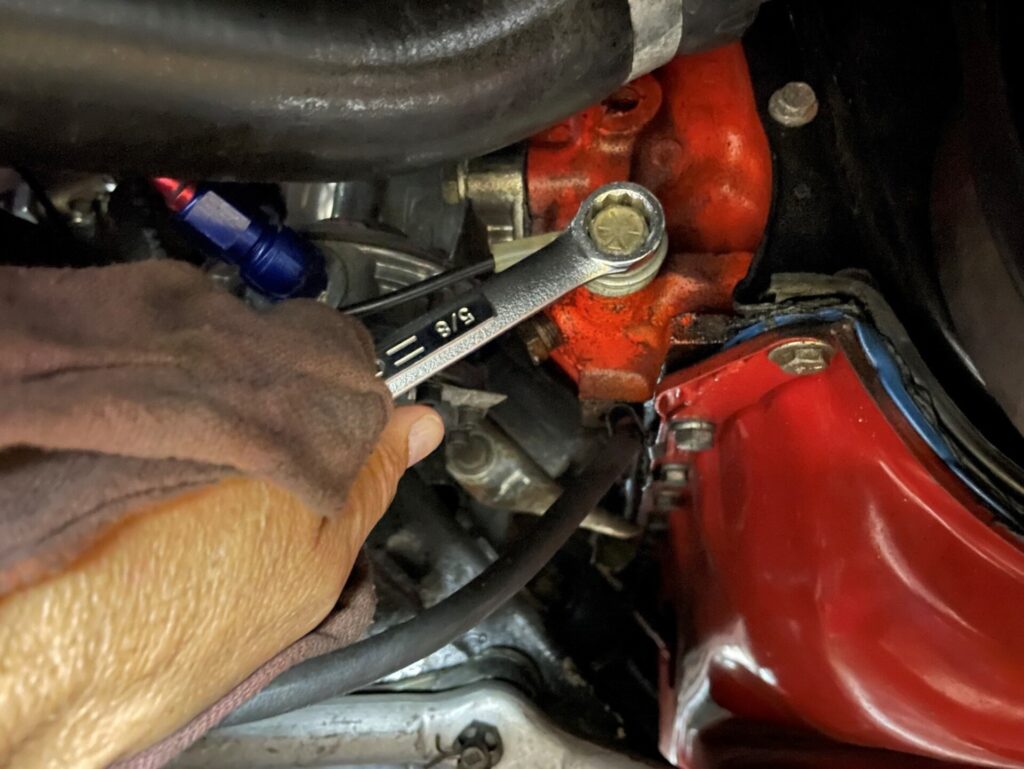 A wrench turning a bolt on a car engine