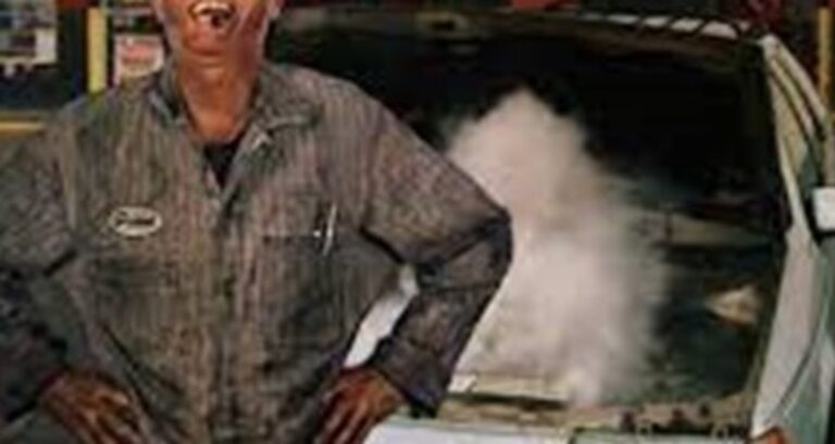 Car mechanic laughing at smoking car