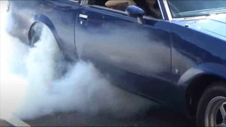 Classic car spinning wheels and making smoke