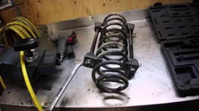 Car coil spring compressor tool mounted on spring