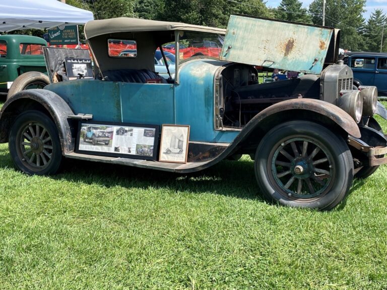 Vintage blue Ford coupe on grass field