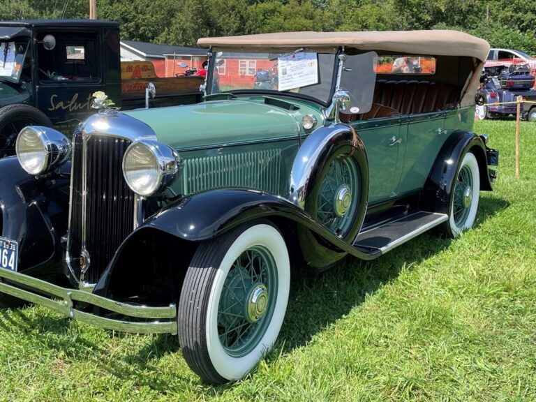 Vintage green Cadillac sedan on grass field