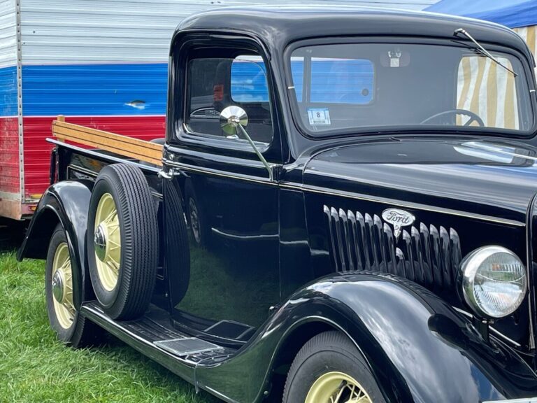 Classic black Ford pickup truck with yellow wheels