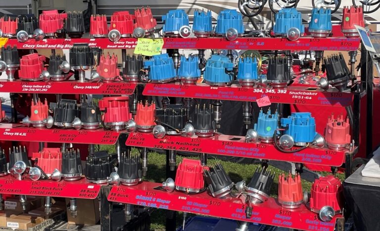 A rack holding classic car distributers with red, blue and black caps