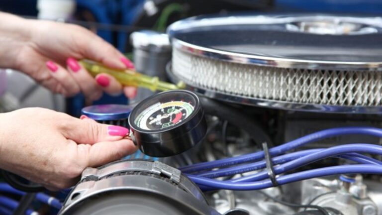 A woman using a vacuum gauge and adjusting a carb