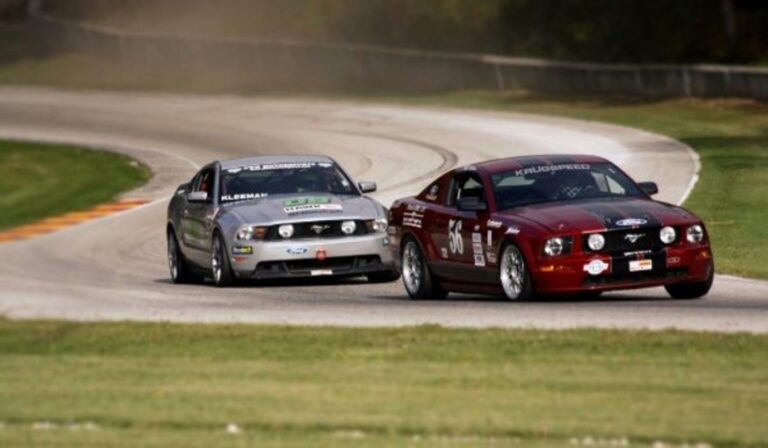 Burgundy and silver Ford Mustangs on a racetrack