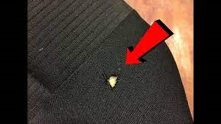 A car carpet with a red arrow pointing to a tear in the carpet