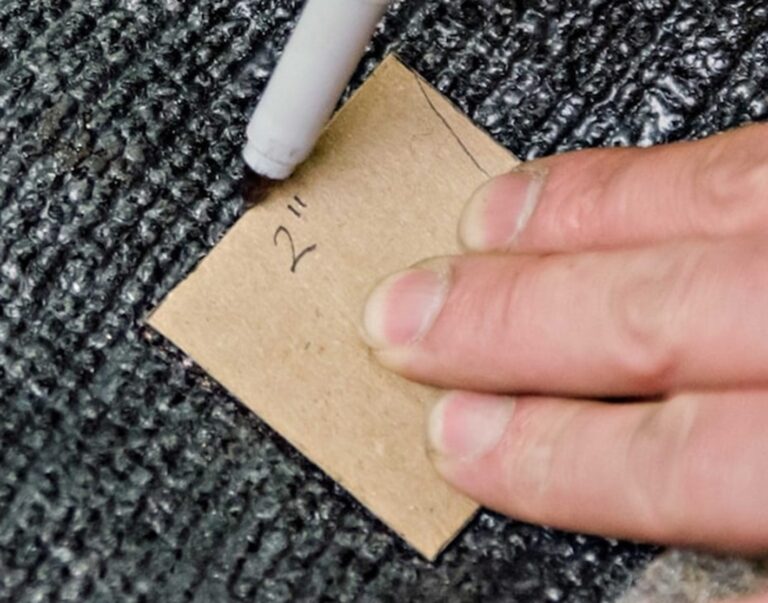 Marking the area of carpet to remove the damaged car carpet for carpet repair