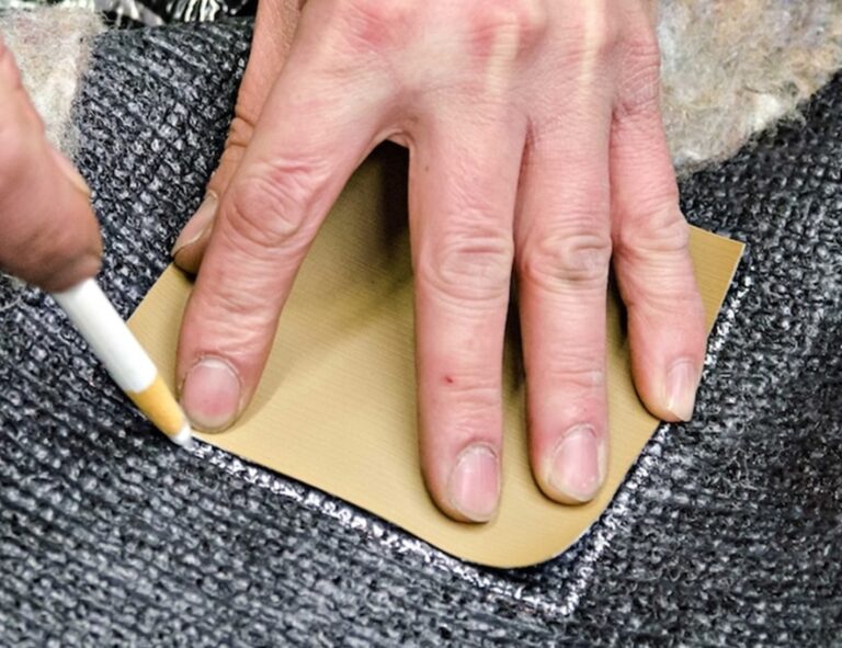 Marking with white marker the carpet repair area