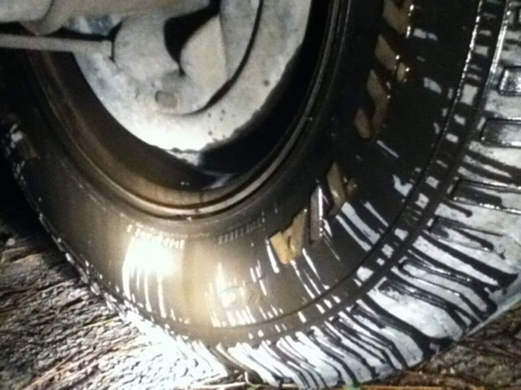 Truck tire noting leaking rear differential fluid from axel