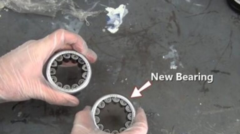 A person holding and comparing the old and new bearings