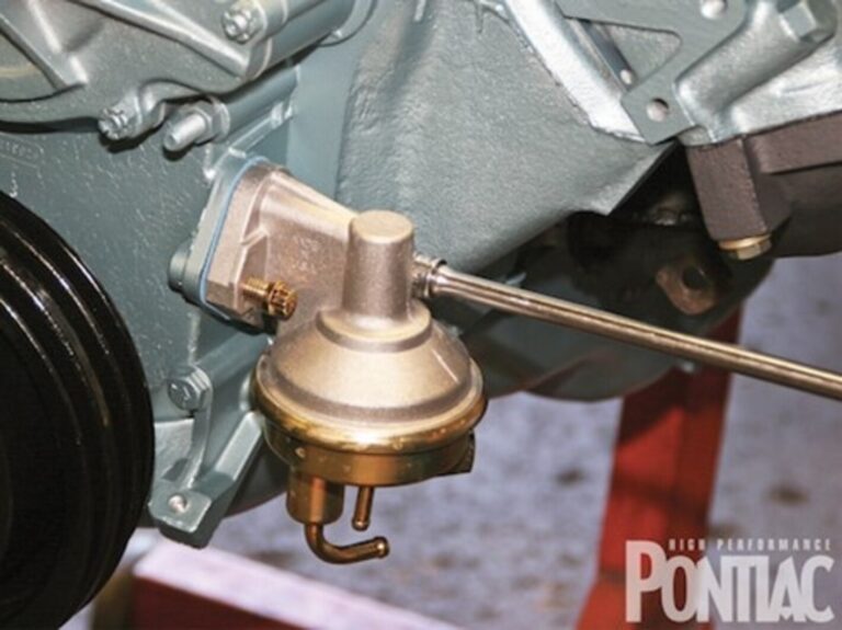 A bronze color Pontiac fuel pump mounted on green engine