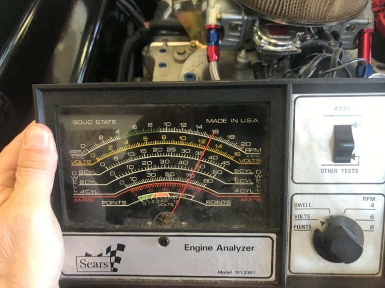 Holding a Sears Engine Analyzer reading the engine volts