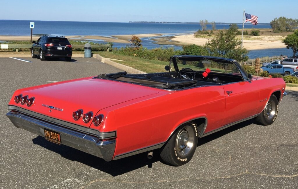Red convertible Chevrolet Impala overlooking the water