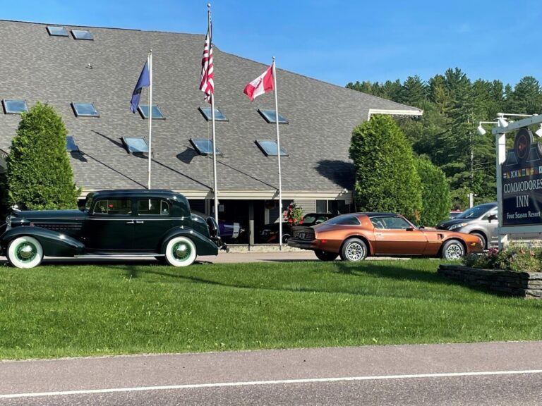 A black Cadillac and gold Trans Am outside of a hotel in Vermont on a road trip