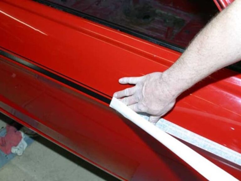 Installing black vinyl side stripes on a red car
