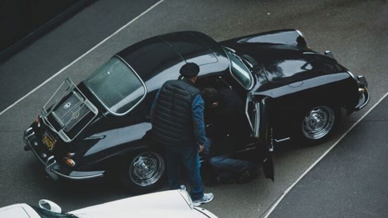 2 men working to steal a black Porsche