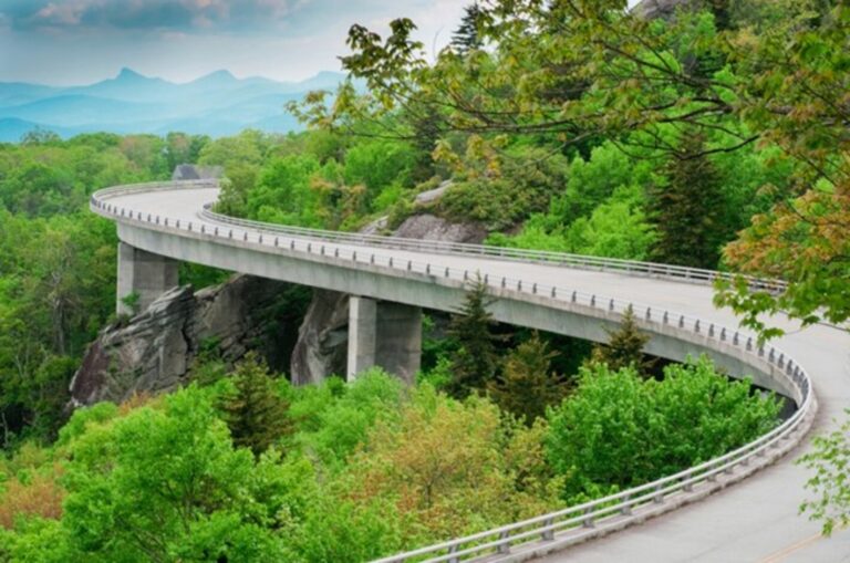 A winding section of the Blue Ridge Pkwy with the mountains in the background