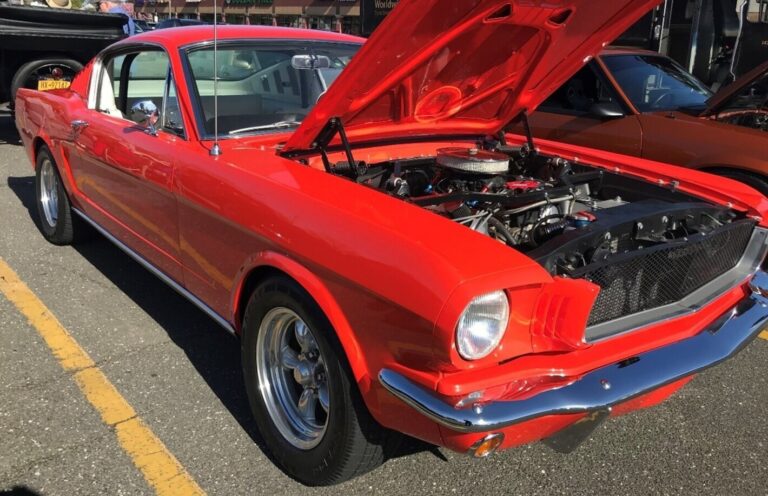 Red Ford Mustang fastback at a car show