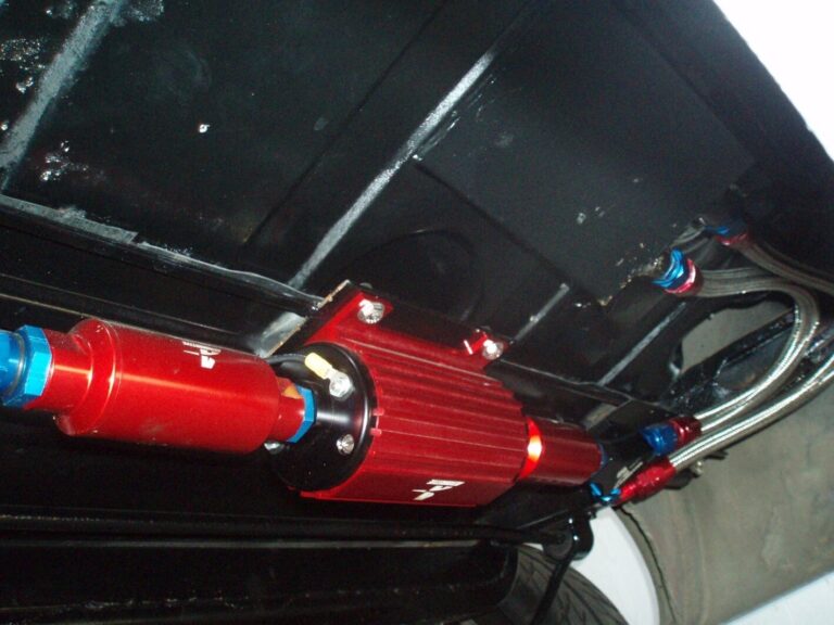 Red electric fuel pump and fuel filter mounted under car gas tank