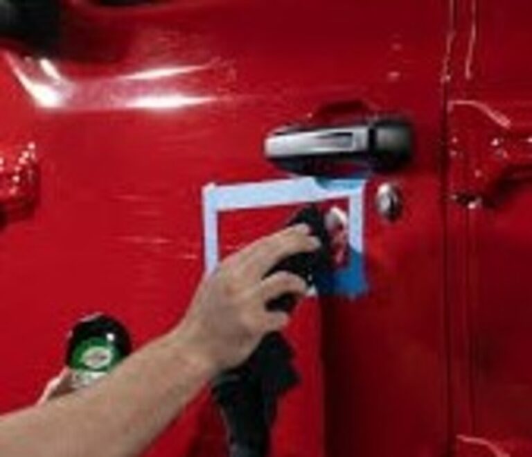 Blending in the side panel of a red car after the touch-up paint is applied