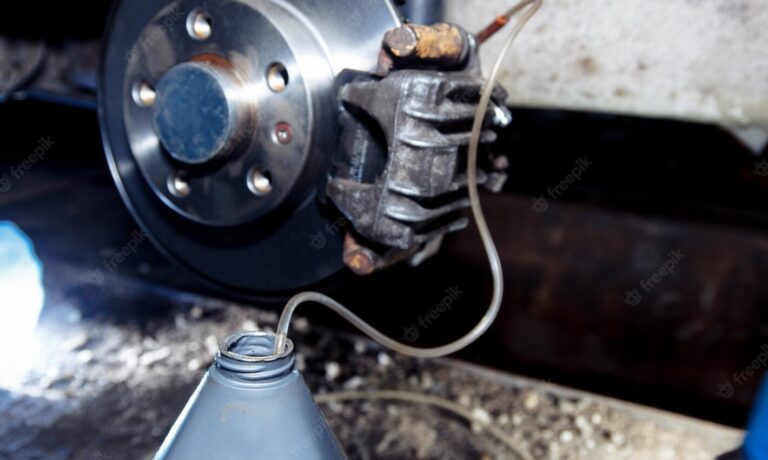 Brake flluid beong flushed thru the brake system in a plastic container via hose