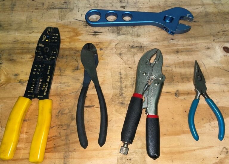 Plyers and wrenches on a wood bench