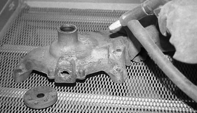 Using a media blaster to remove corrosion from a water pump during the rebuilding process