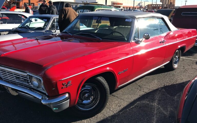 A red 65 Chevy Impala convertible for sale at a car show in Arizona
