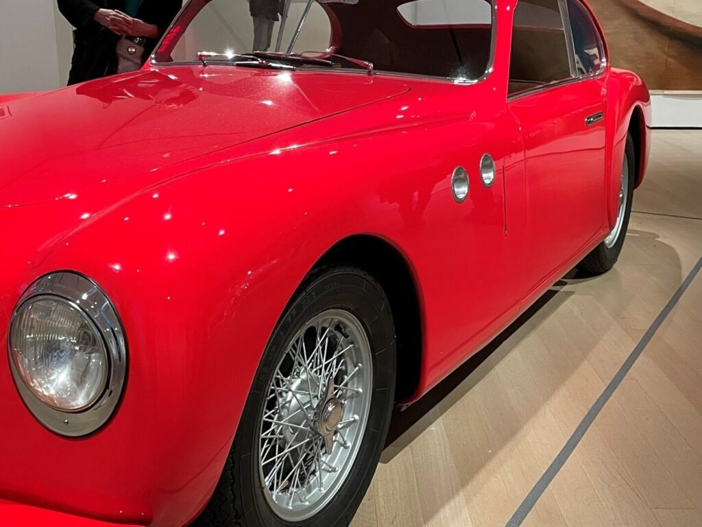 A red British sports car in a museum
