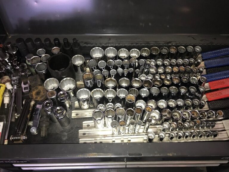 A drawer of a black toolbox filled with sockets