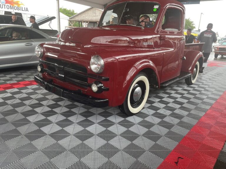 A burgundy 50s custom Chevy pickup truck on the staging lane at classic car auctions