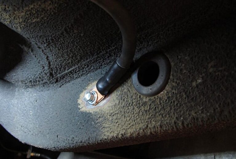 A black #1 gauge ground wire connected to the car frame under the car trunk for battery relocation