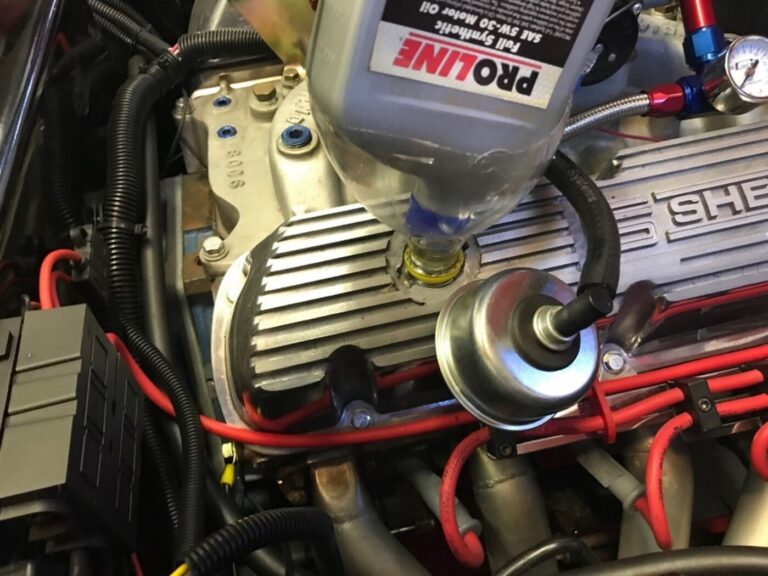 Pouring oil into a Ford engine with silver valve covers