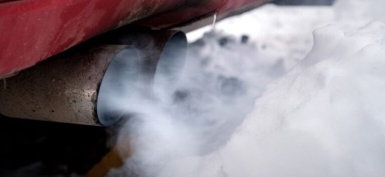 A red car with white smokey exhaust
