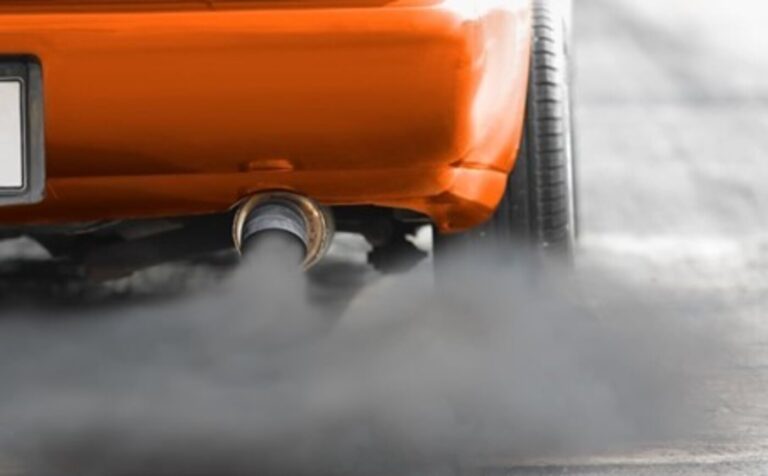 An orange car with black smokey exhaust