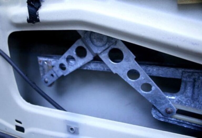A window mechanism inside a door panel on a white car