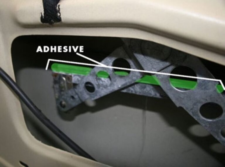 A view of a car door window mechanism noting where to put the adhesive material to fix a loose window