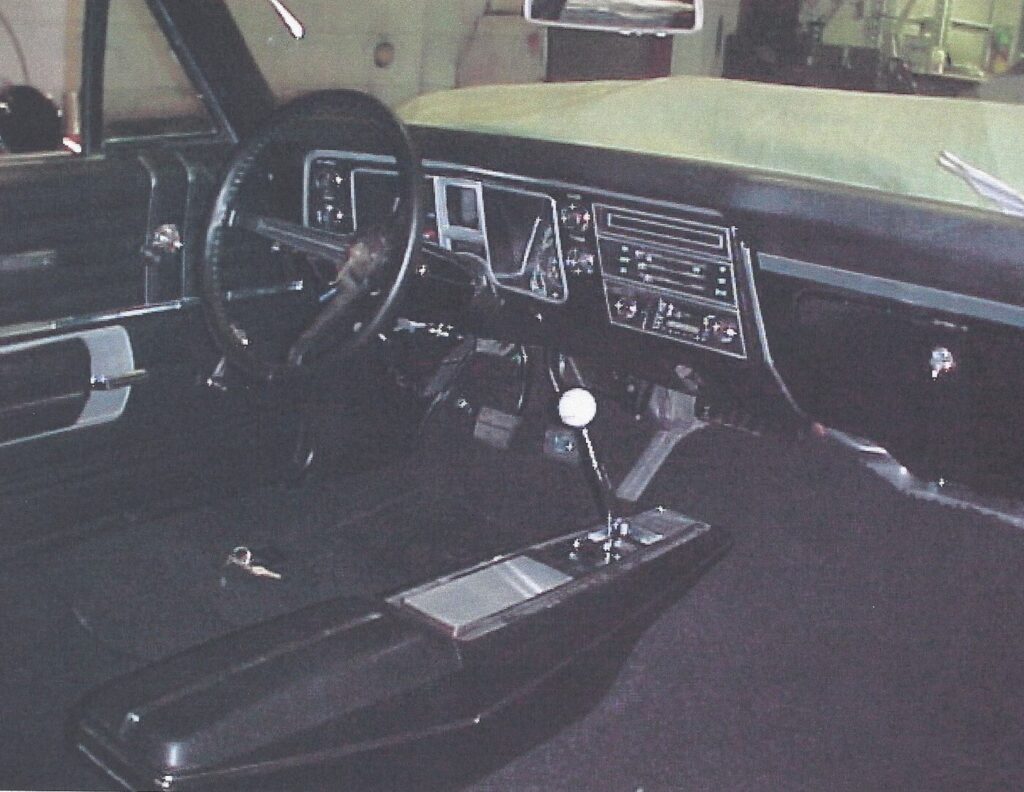 A black Interior of a 68 Chevy Chevelle with dash, center console, and newly installed car's interior carpet