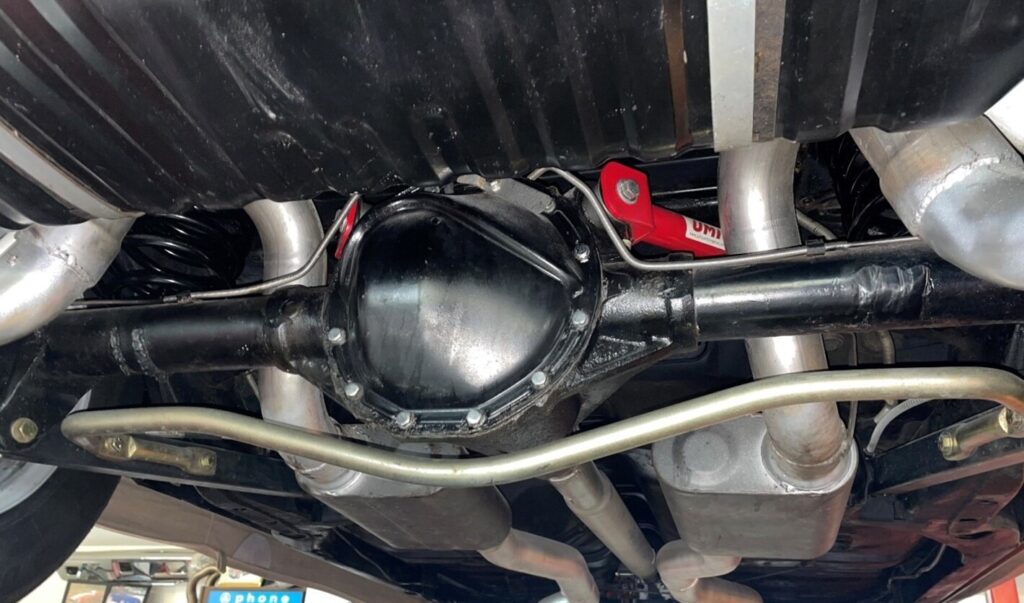 A black GM 12-bolt rear axels in a 68 Chevy Chevelle with gold sway bar and silver exhaust under the car