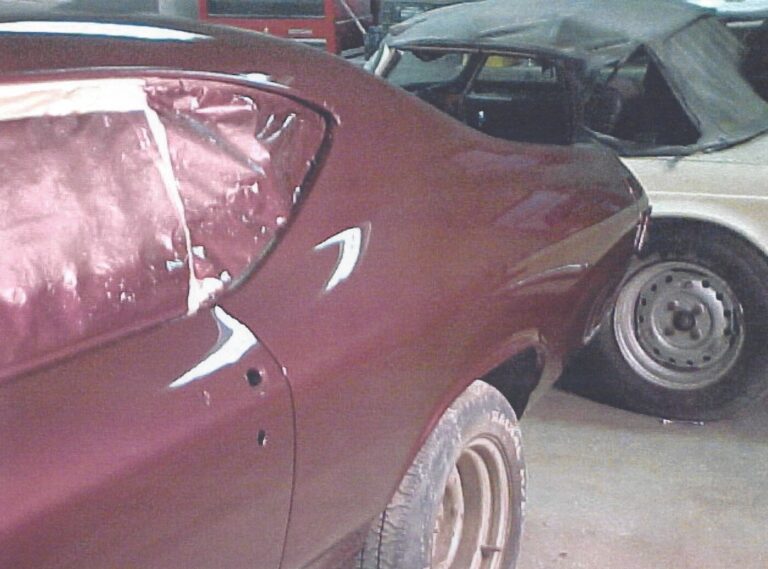 68 Chevy Chevelle with freshly painted marron car paint parked in front of a white Triumph convertible