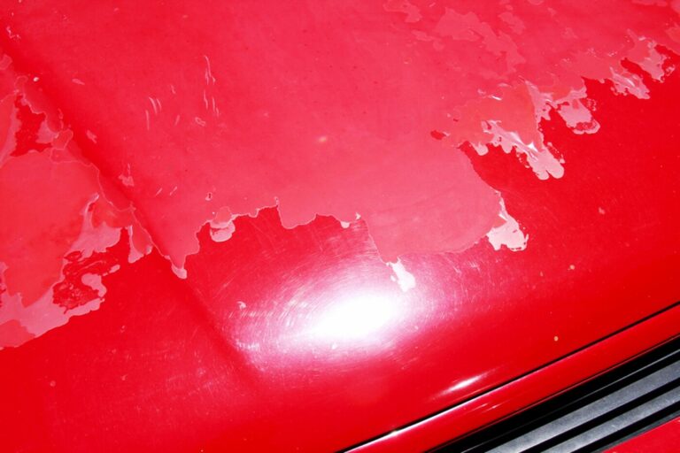 Red car hood showing signs of clear coat pealing