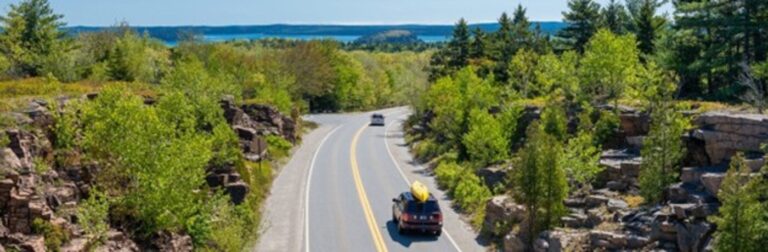 An overhead view along a coastal road in Maine with water in the background for road trips