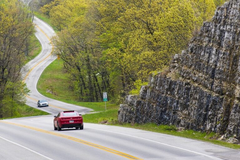 The winding road thru the mountains with a red Chevy Camaro heading away in Arkansas for road trips