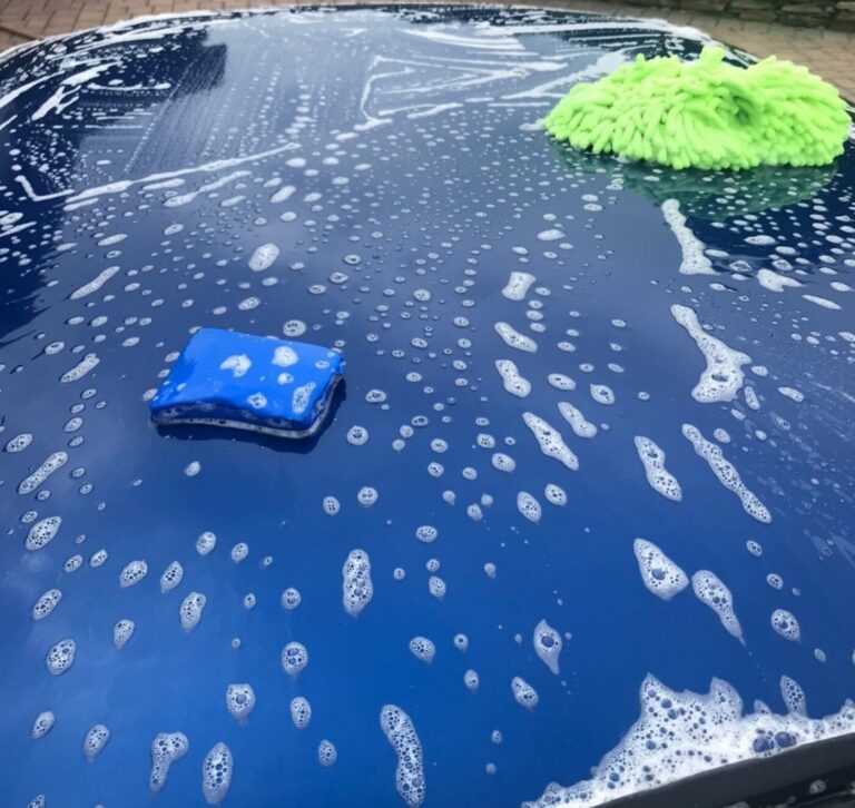 Cleaning a blue Corvette roof with automotive soap, sponge, and washing Mit before car polishing