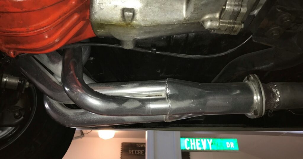 Silver polished headers on a big blog Chevrolet engine as part of an exhaust system